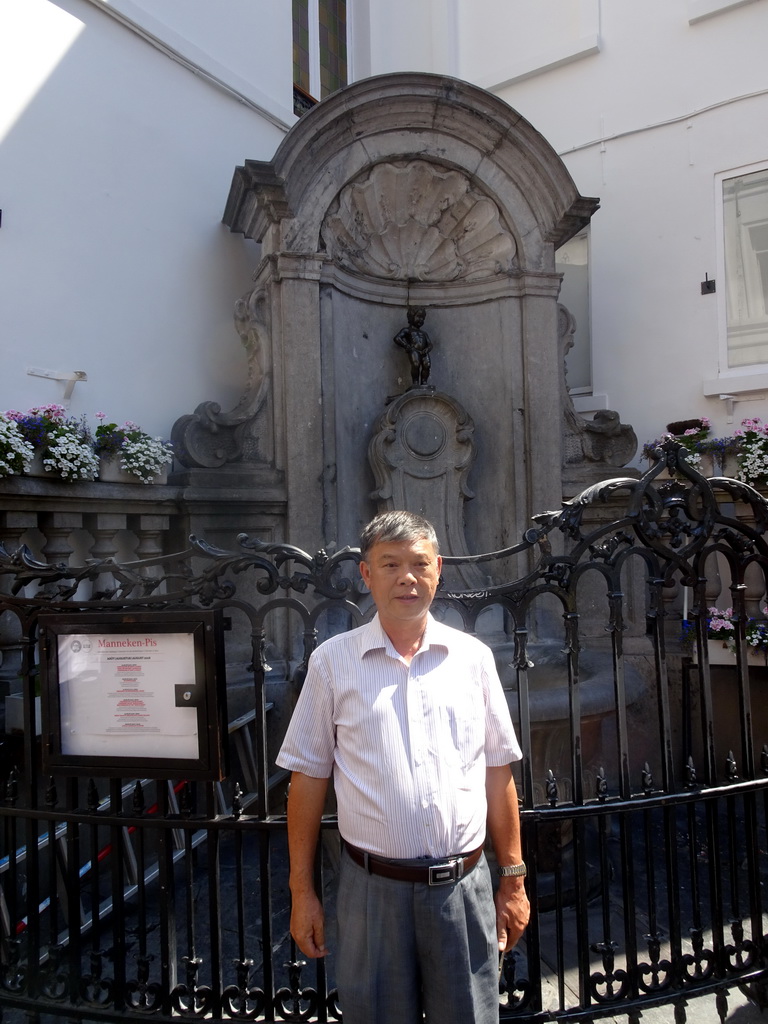 Miaomiao`s father in front of the fountain `Manneken Pis` at the crossing of the Rue de l`Étuve street and the Rue du Chêne street