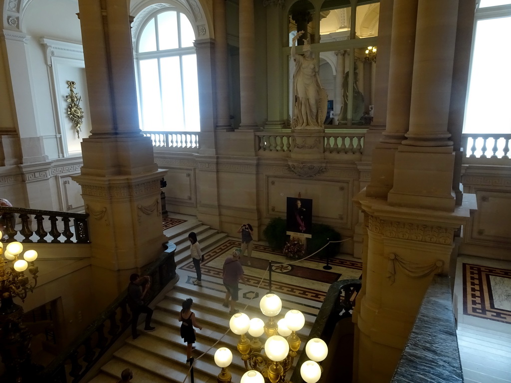 The Grand Staircase of the Royal Palace of Brussels with a statue of Minerva and a photograph of King Baudouin