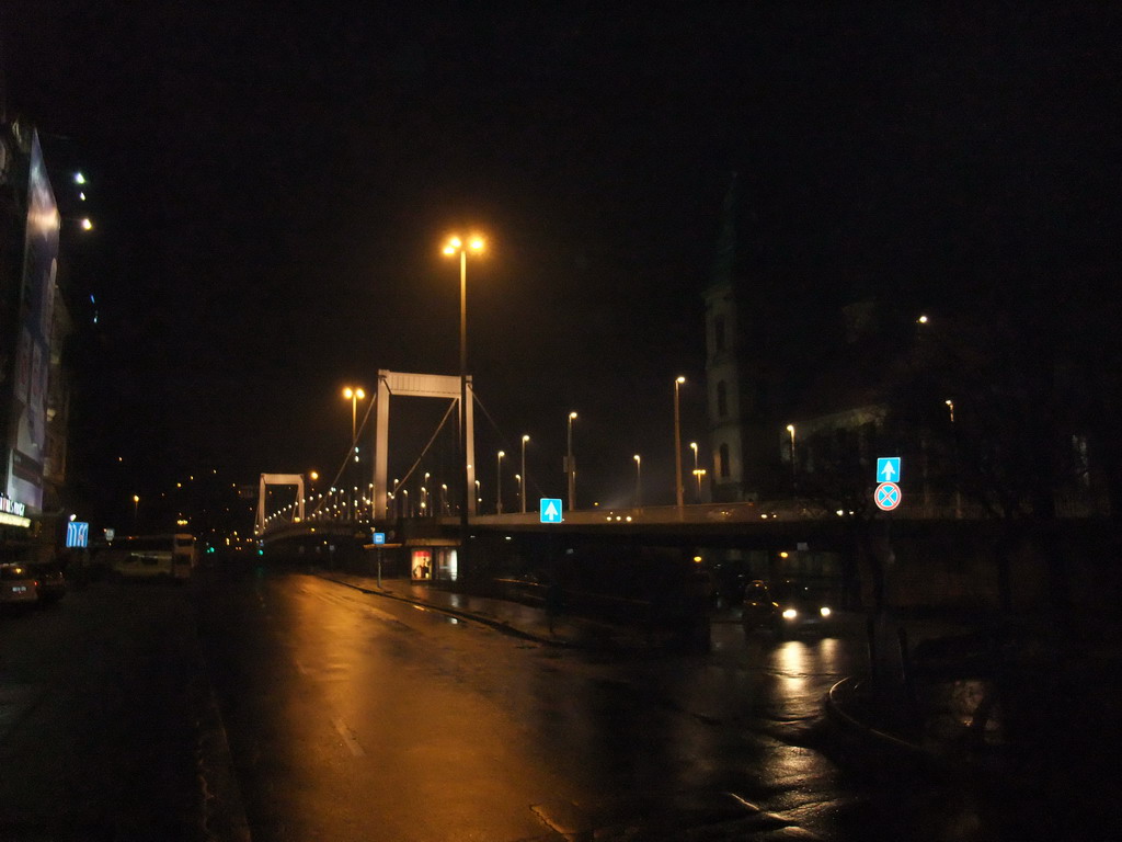 The Elisabeth Bridge (Erzsébet Bridge) over the Danube river, the Inner City Parish Church (Belvarosi Plebaniatemplom) and the Marcius 15. Tér square, by night