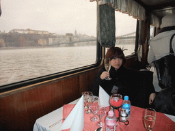 Miaomiao with wine at the cruise boat on the Danube river, with the Széchenyi Chain Bridge and the Matthias Church