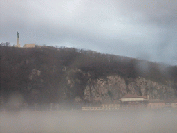 The Liberty Statue and Gellért Hill in the myst, from the cruise boat on the Danube river