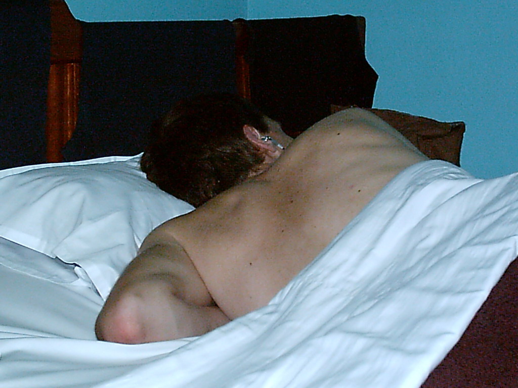 Tim lying in bed in our hotel room