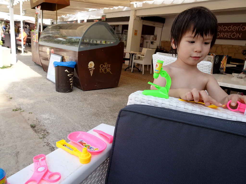 Max playing with doctor toys at the Heladería Torreón restaurant at the Cala Gran beach