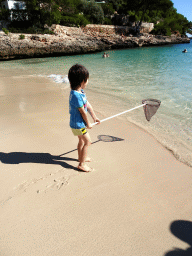 Max with a fishing net at the Cala d`Or beach