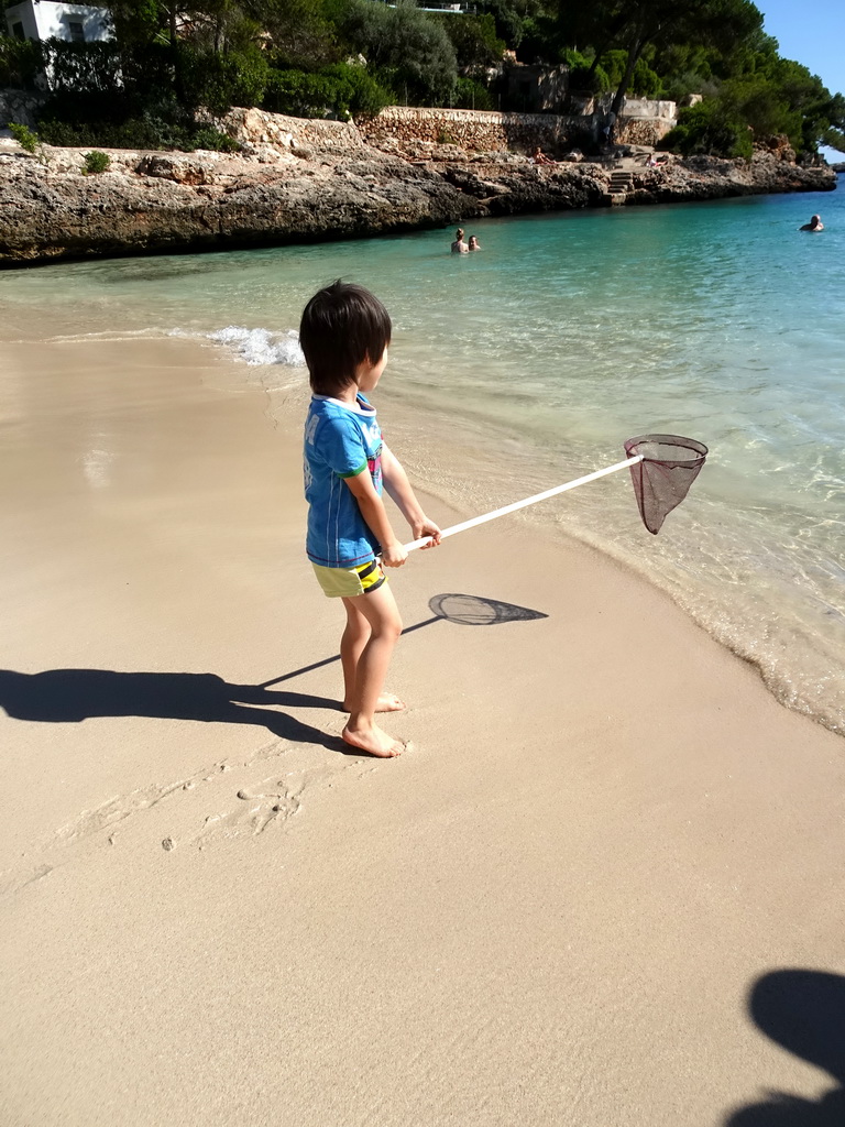 Max with a fishing net at the Cala d`Or beach