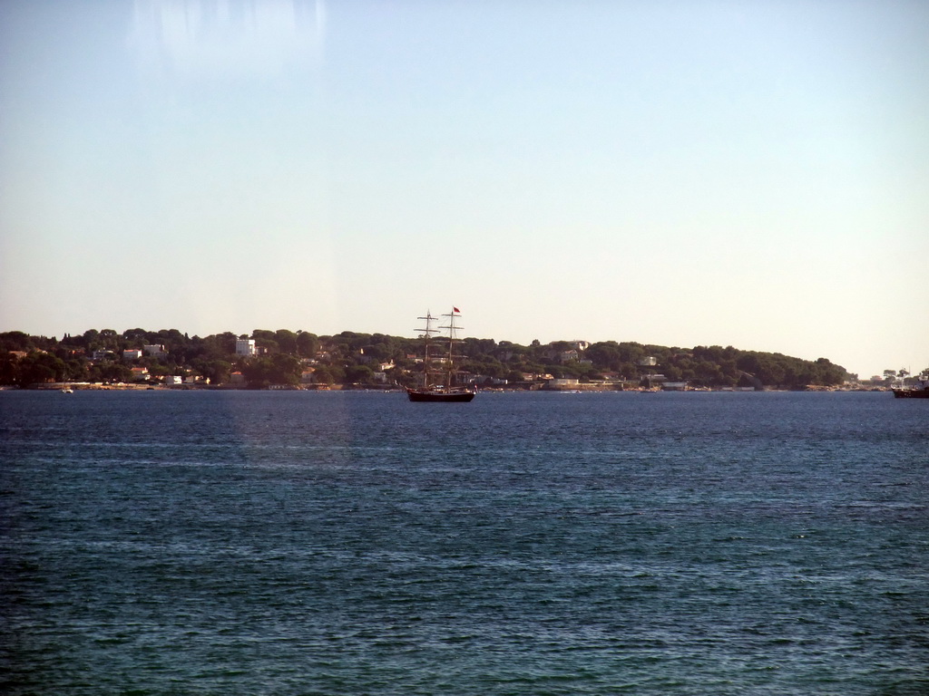 Seaside and a boat in the Mediterranean Sea, viewed from train from Nice