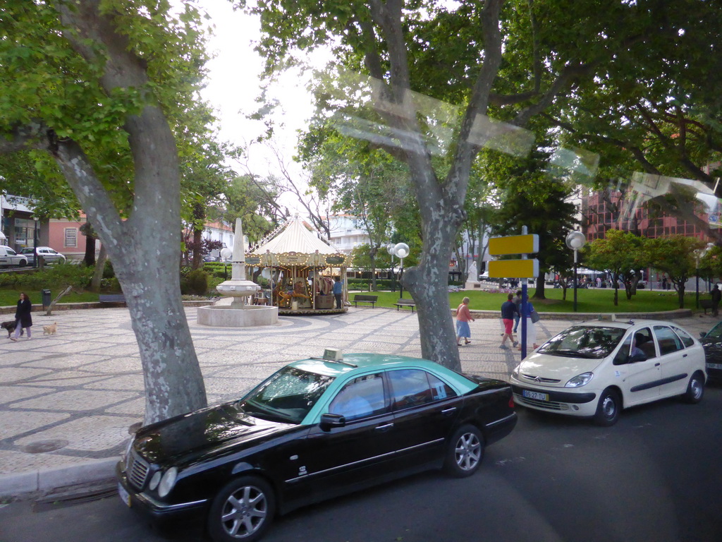 Fountain and carousel at the Jardim Visconde da Luz garden, viewed from the bus to Lisbon