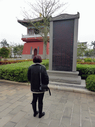 Miaomiao with a stone with information on the history of the Yongqing Temple and a tower at the front square of the Yongqing Temple