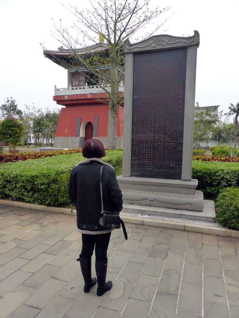 Miaomiao with a stone with information on the history of the Yongqing Temple and a tower at the front square of the Yongqing Temple