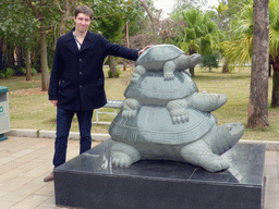 Tim with a statue of three tortoises at the front square of the Yongqing Temple