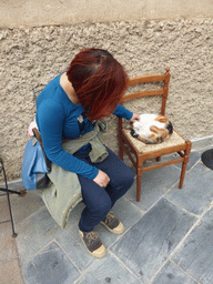 Miaomiao with a cat on a chair on the side of the Chiesa di San Lorenzo church at Manarola