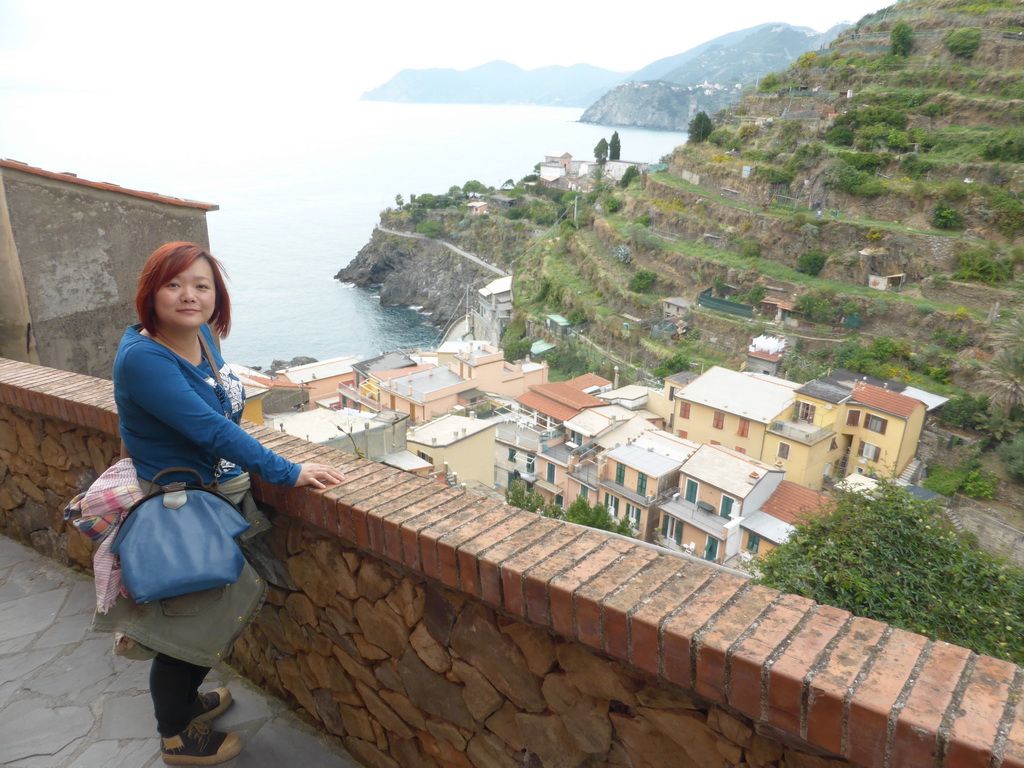 Miaomiao at the Via Rolandi street with a view on the town center of Manarola, a hill with wine fields, the Punta Bonfiglio hill, Monterosso al Mare and Corniglia