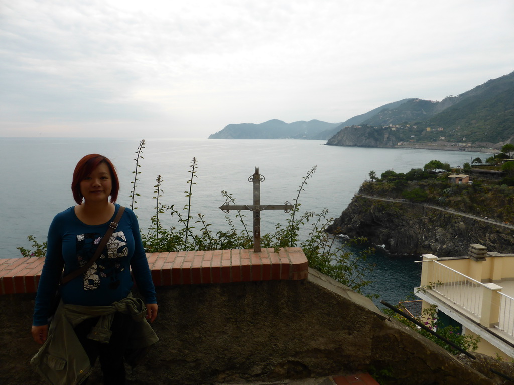 Miaomiao and a cross at the Via Belvedere street at Manarola with a view on the Punta Bonfiglio hill and the Via dei Giovani path to Corniglia