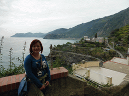 Miaomiao and a cross at the Via Belvedere street at Manarola with a view on the Punta Bonfiglio hill and the Via dei Giovani path to Corniglia