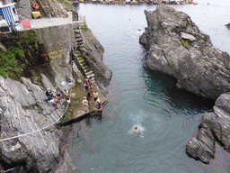 People swimming in the harbour of Manarola