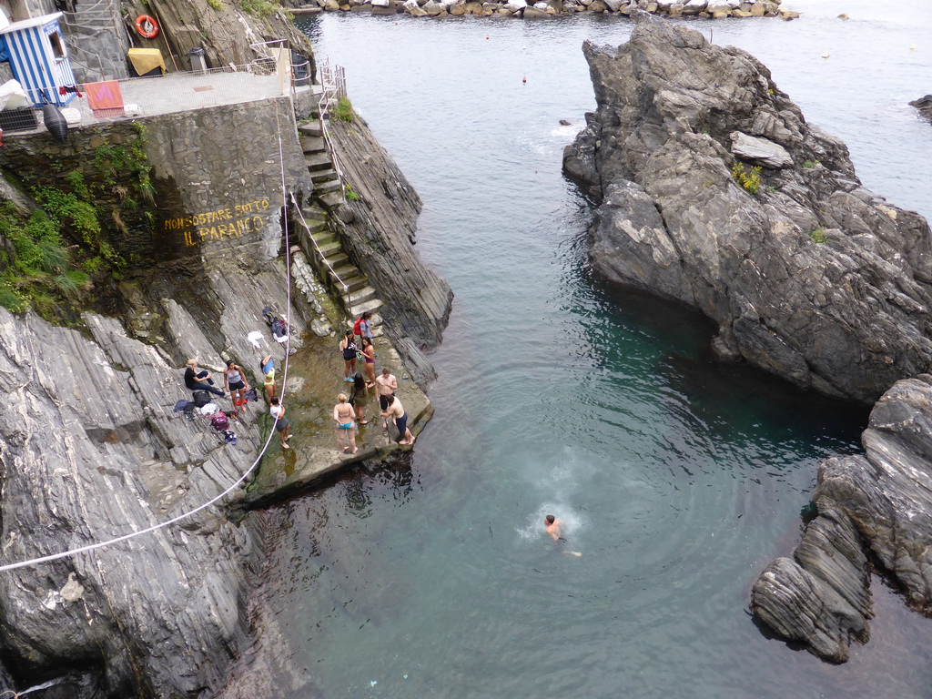 People swimming in the harbour of Manarola