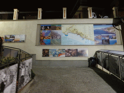 Map and photos on the wall of the Piazza Dario Capellini square at Manarola, by night