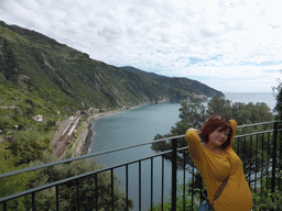 Miaomiao at a viewing point near the Corniglia Cemetery, with a view on the Corniglia railway station and Manarola