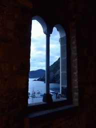 Window at the Chiesa di Santa Margherita d`Antiochia church at Vernazza, with a view on the harbour and Monterosso al Mare, at sunset