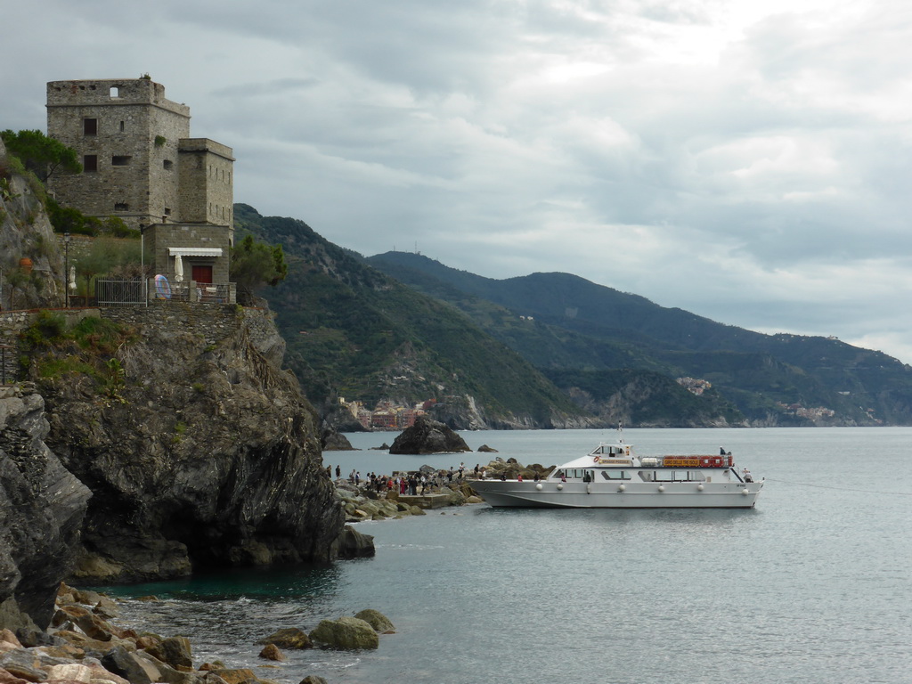 The Torre Aurora tower at Monterosso al Mare and the ferry to Vernazza, with a view on Vernazza, Corniglia and Manarola