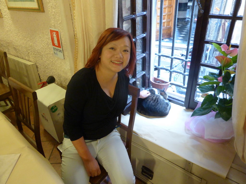 Miaomiao with a cat at the Pizzeria da Ely restaurant at Monterosso al Mare