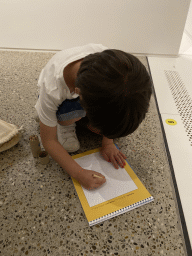 Max drawing in the book with scavenger hunt at the Family of Man exhibition at Clervaux Castle
