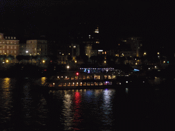Boat in the Rhein river, viewed from the Kennedy-Ufer street, by night