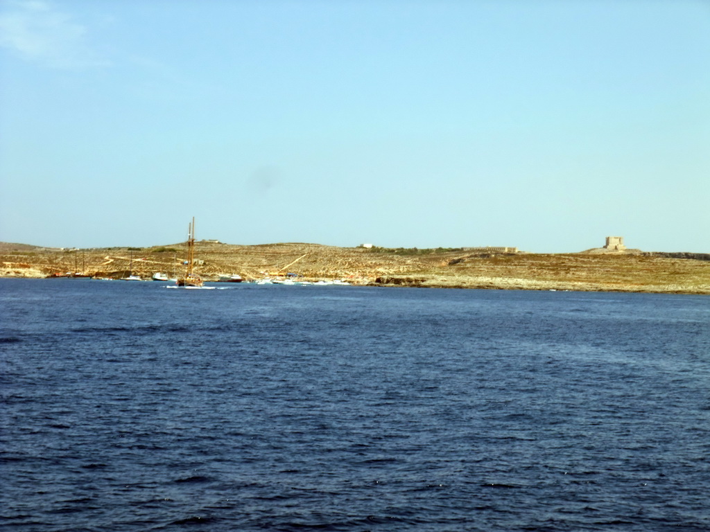Boats at the Blue Lagoon (Bejn Il-Kmiemen) and St. Mary`s Tower, viewed from the Luzzu Cruises tour boat from Gozo to Comino