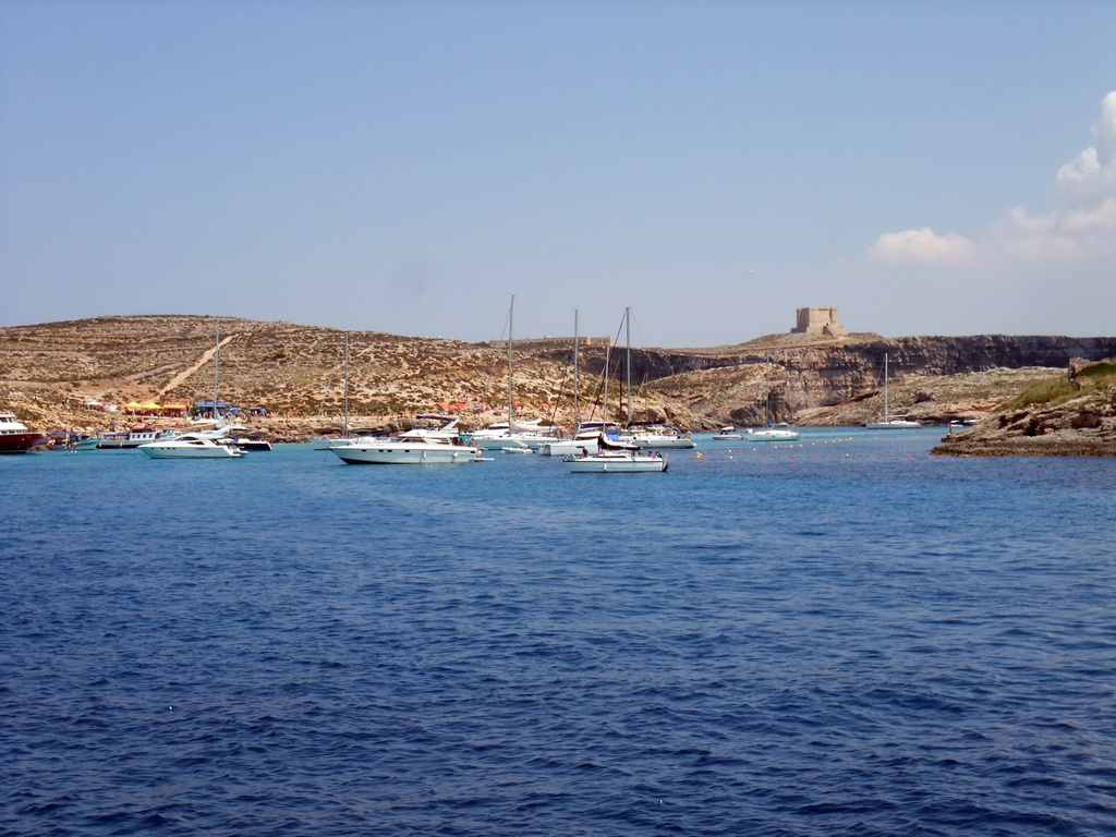 Boats at the Blue Lagoon and St. Mary`s Tower, viewed from the Luzzu Cruises tour boat from Gozo to Comino