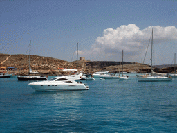 Boats at the Blue Lagoon and St. Mary`s Tower, viewed from the Luzzu Cruises tour boat from Gozo to Comino