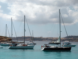 Boats at the Blue Lagoon, Cominotto island and the east coast of Gozo with the town of Ghajnsielem with the Ghajnsielem Parish Church, viewed from the Luzzu Cruises tour boat from Gozo to Comino