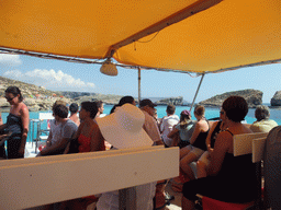 The deck of the Luzzu Cruises tour boat from Comino to Malta, with a view on the Blue Lagoon, St. Mary`s Tower and Cominotto island