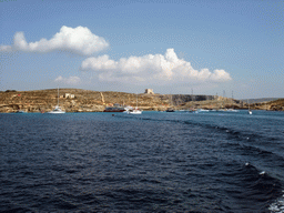 Boats at the Blue Lagoon and St. Mary`s Tower, viewed from the Luzzu Cruises tour boat from Comino to Malta