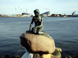 The statue `The Little Mermaid` at the Langelinie pier, with a view on the Amagerværket power station, Christian VI`s Battery, the Nyholm Central Guardhouse and the Masting Crane