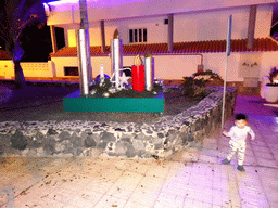 Max with the candle statues at the park at the east side of the Calle El Muelle street, by night