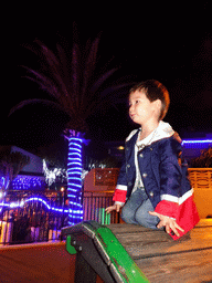 Max on top of a train at the playground at the Calle los Pescadores street, by night