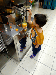 Max making orange juice at the HiperDino supermarket at the ground floor of the Siam Mall