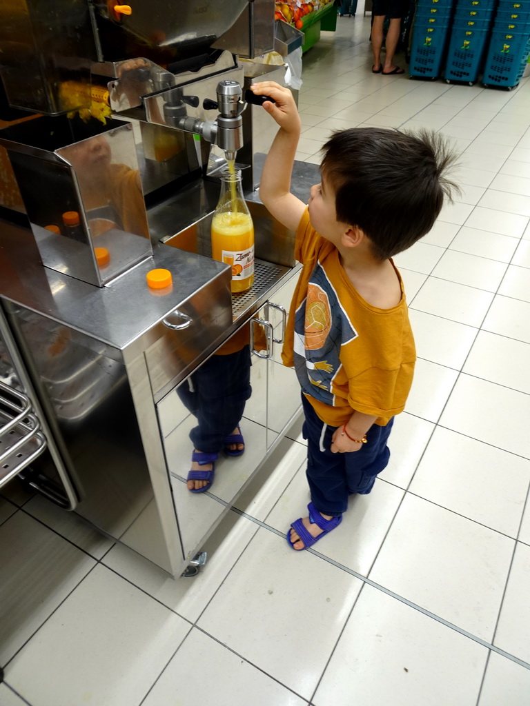 Max making orange juice at the HiperDino supermarket at the ground floor of the Siam Mall