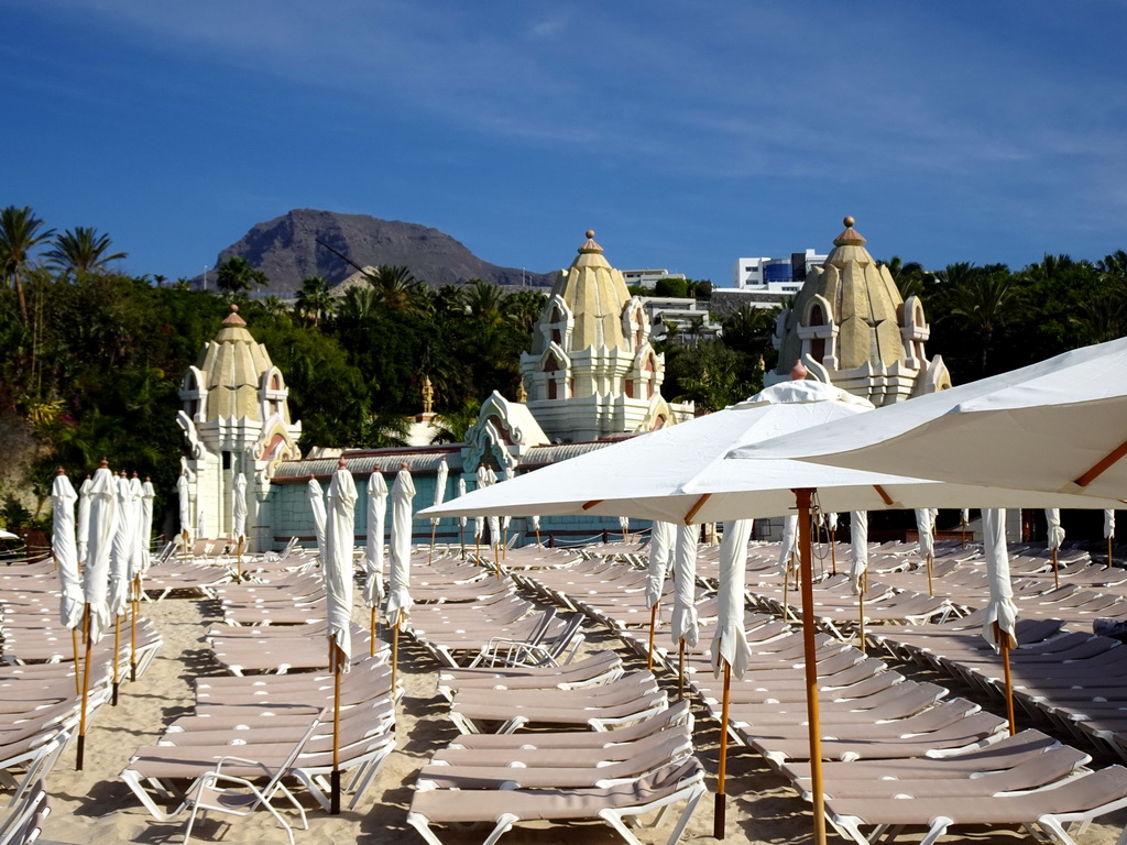 Sunbeds and building at Siam Beach at the Siam Park water theme park, with a view on the Roque Del Conde mountain
