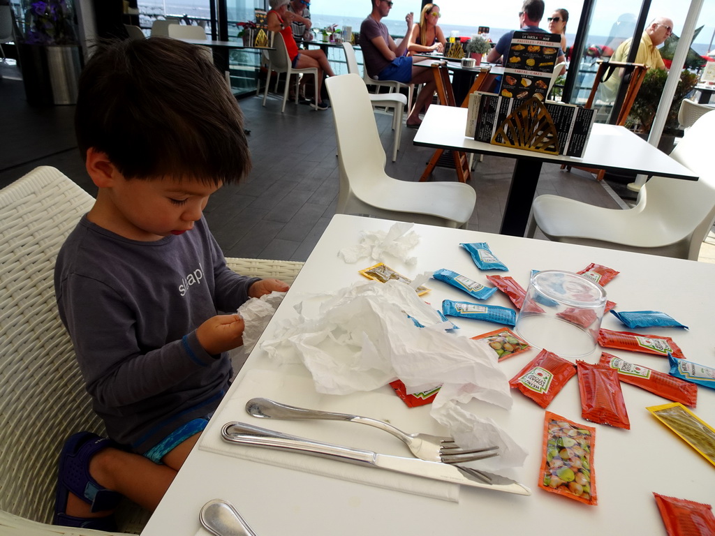 Max playing with tomato ketchup, mayonnaise and mustard at the Restaurante La Farola del Mar