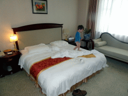 Max on the bed in our first bedroom at the New Sea View International Hotel