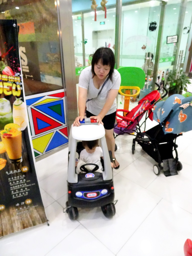 Miaomiao and Max in a toy police car in a shopping mall at Fushun Street