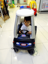 Max in a toy police car in a shopping mall at Fushun Street