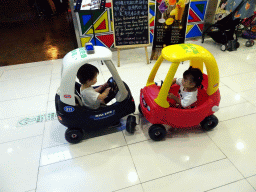 Max and his cousin in toy cars in a shopping mall at Fushun Street