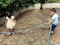 Max and his cousin with a garden hose at the square next to the photoshoot shop at Jinma Road