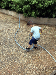 Max with a garden hose at the square next to the photoshoot shop at Jinma Road