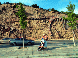 Miaomiao and Max in front of the rock with dinosaur skeletons at Binhai Road