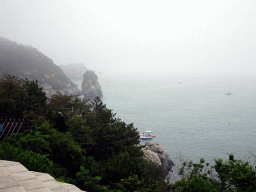 Rocks, trees and boats at the Dalian Jinshitan Coastal National Geopark, viewed from the viewing point near the entrance