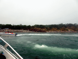 Rocks, beach and another ferry at the Dalian Jinshitan Coastal National Geopark, viewed from the ferry