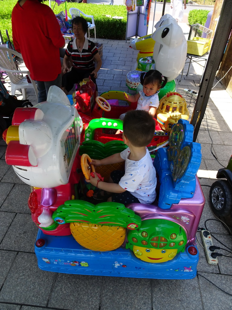 Max with his cousin and grandmother at the toy cars at the playground at Haibin Park
